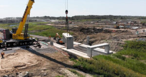 A crane elevates a concrete bench, showcasing its strength at a building site.