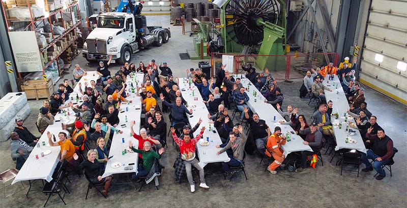 A lively MCON team christmas party featuring people gathered around tables, sharing laughs and good times.